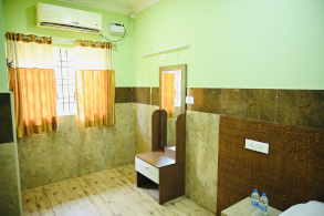 Non-AC budget room at Hotel Parijatha Inn Dharmasthala — clean room with fan for pilgrims